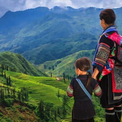 Black Hmong mother and child looking over rice terrace in Sapa, Vietnam